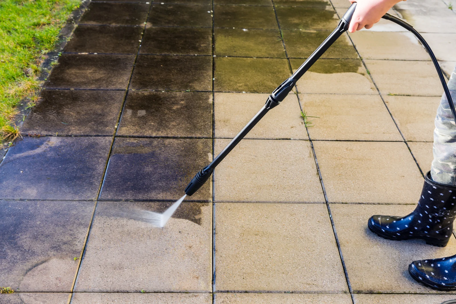 Before and after view of a patio being pressure washed clean